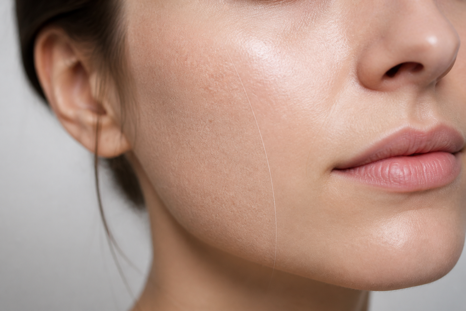Close-up of facial skin showing a smooth hydrated area beside a slightly dry textured area
